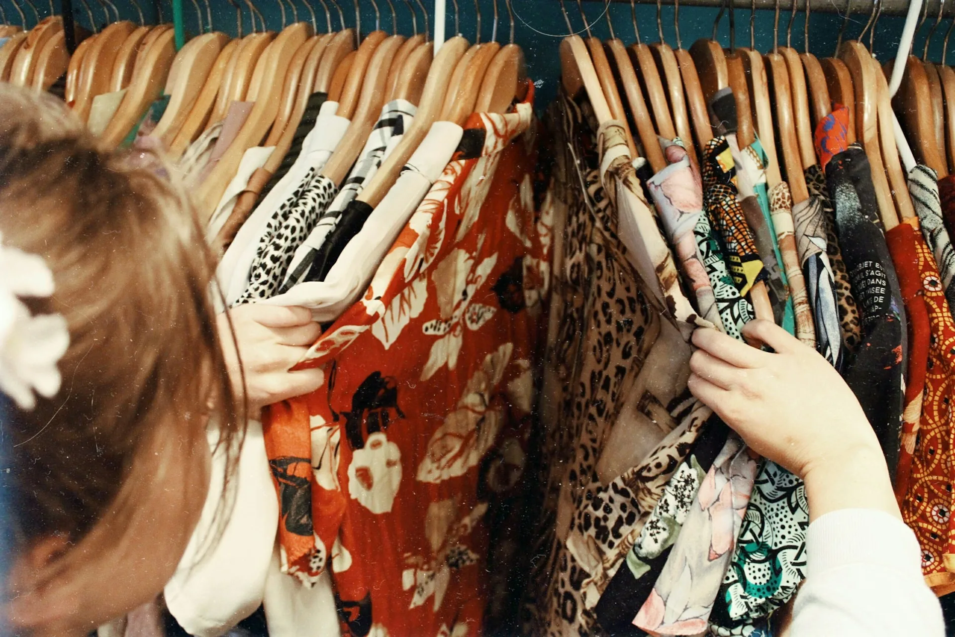 Rack of stylish wedding guest dresses in various colors and styles displayed in a boutique, showcasing options for black tie and formal events.